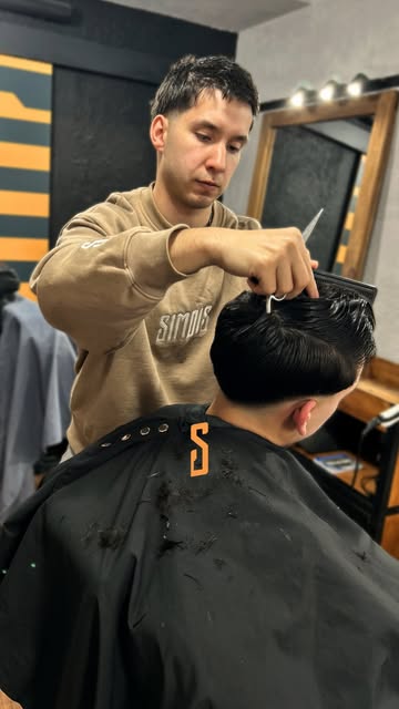Barbero de Simois cortando con tijera en el local